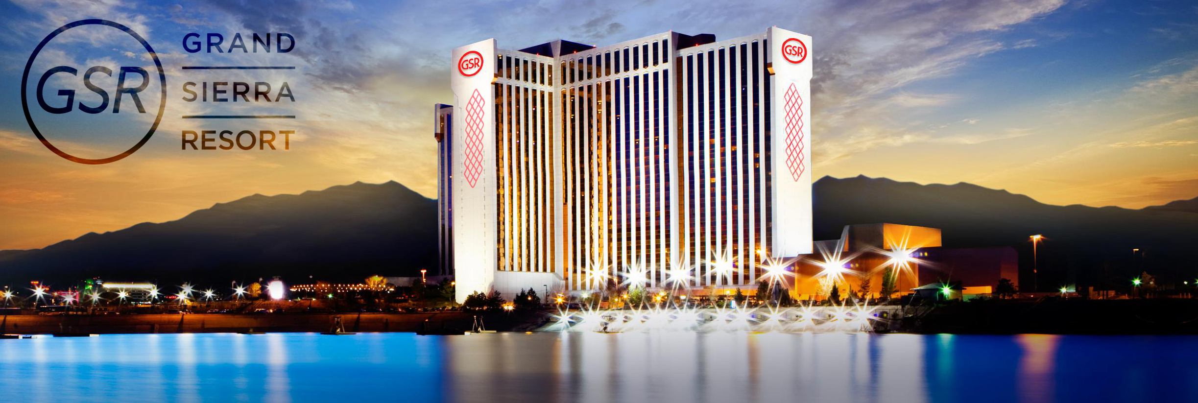 Exterior of the Grand Sierra Resort at sunset, reflected in the water with mountains in the background