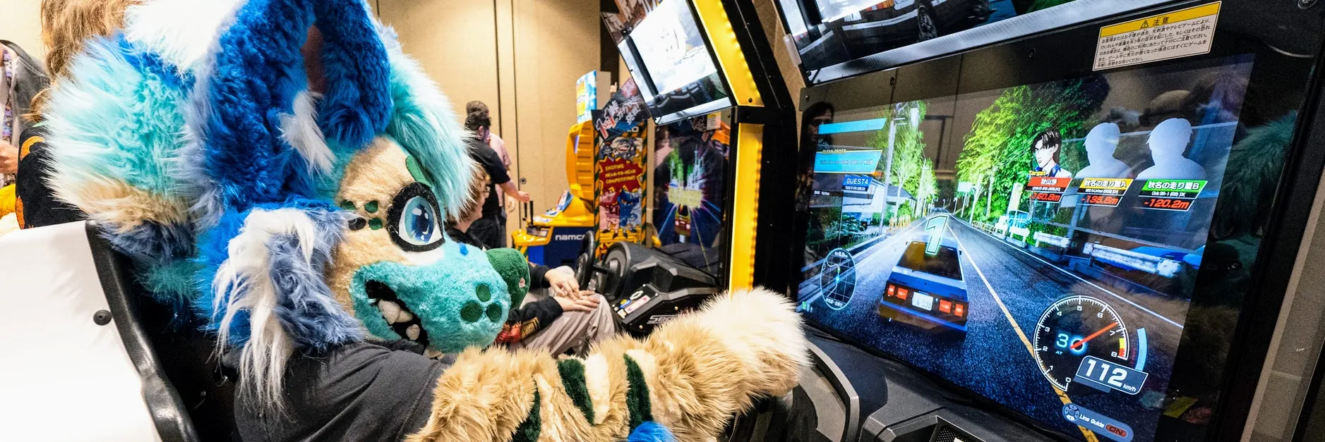 Fursuiter playing a racing arcade game