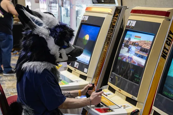 Fursuiter playing an arcade cabinet